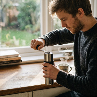 homme utilise moulin à café compact inox