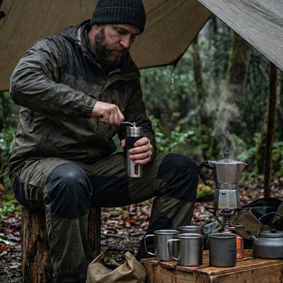 homme utilise moulin à café cortado au camping